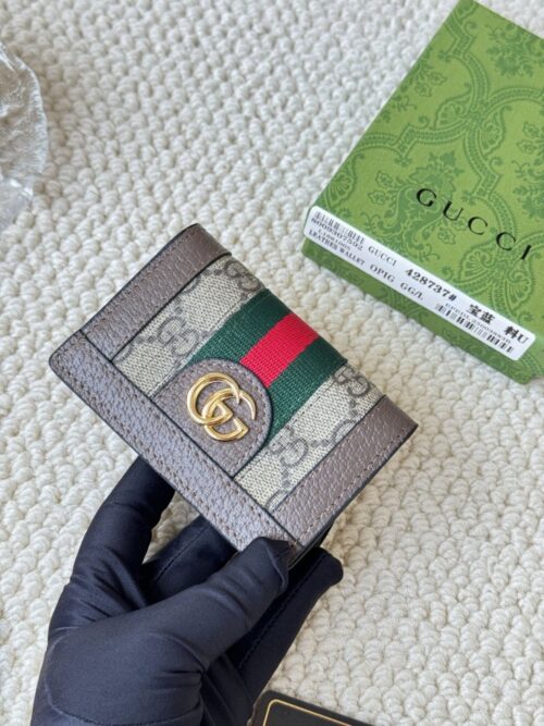 【AT1853】GUCCI グッチの折りたたみカードケースは、目立つアイコンとしてのダブルGの金属アクセサリーが付いています。キャンバス生地とウェビング素材で作られており、編み目の外観を演出しています。