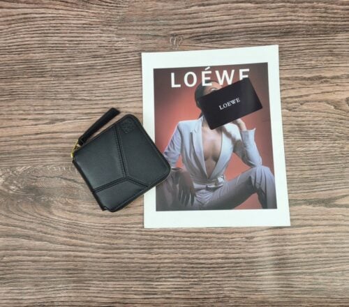 【AT1861】LOEWE（ロエベ）の二つ折り財布は、ラウンドファスナーとアナグラムのデザインが特徴的です。スクエアな形状で、高品質のレザー製で、ブラックのカラーがエレガントな印象を与えます。