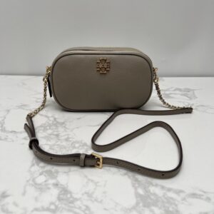 【AT2532】Tory Burchの新作カメラバッグ。リッチなリザード柄牛革製。ショルダーと斜め掛けができる小さな丸いバッグ。牛革製の斜めがけバッグ。ダブルジップ。