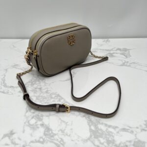 【AT2532】Tory Burchの新作カメラバッグ。リッチなリザード柄牛革製。ショルダーと斜め掛けができる小さな丸いバッグ。牛革製の斜めがけバッグ。ダブルジップ。