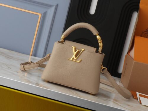 【AT2575】このLV Capucinesミニハンドバッグは、ハンドルに繊細なモノグラムの花柄が取り入れられており、立体的なLVロゴを繊細なタッチで表現しています。柔らかなデザインに鮮やかな輝きを与えています。