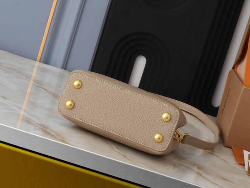 【AT2575】このLV Capucinesミニハンドバッグは、ハンドルに繊細なモノグラムの花柄が取り入れられており、立体的なLVロゴを繊細なタッチで表現しています。柔らかなデザインに鮮やかな輝きを与えています。