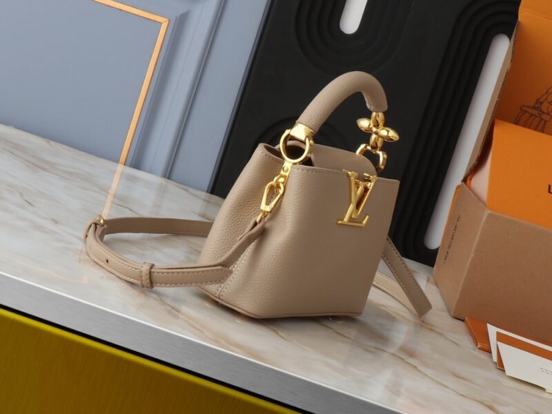 【AT2575】このLV Capucinesミニハンドバッグは、ハンドルに繊細なモノグラムの花柄が取り入れられており、立体的なLVロゴを繊細なタッチで表現しています。柔らかなデザインに鮮やかな輝きを与えています。